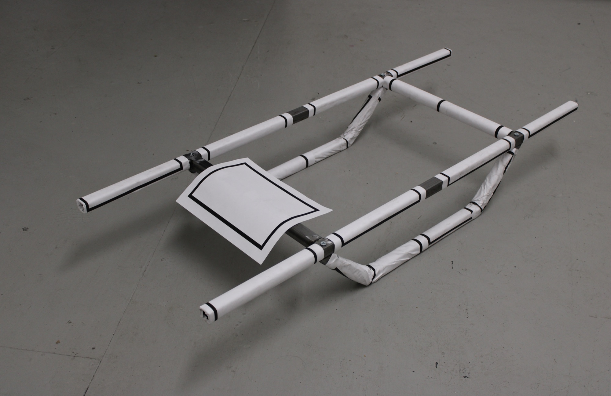 Confinement, 2026 — installation view, welded steel frame wrapped in blank shiva mourning notices