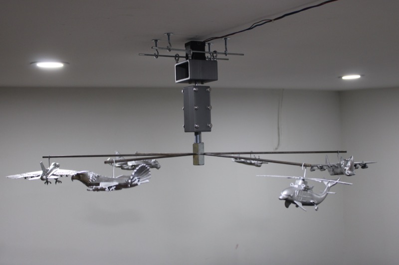Mobilized, 2026 — plane-animal hybrids suspended from a rotating steel-wire mobile